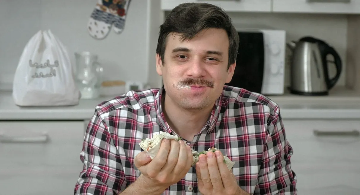 Man quickly eats five more bites of shawarma before satiety signals reach his brain image
