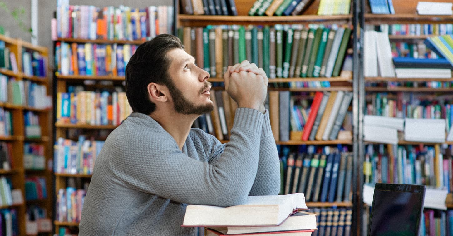 صورة طالب يُمضي ليلة الامتحان بقراءة كتيّب الأدعية لأن الوقت لم يسعفه بذلك طوال الفصل الدراسي