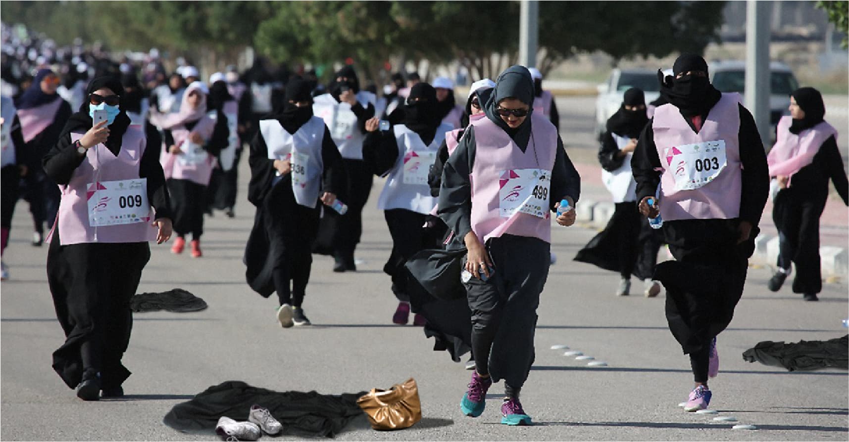 صورة ذوبان ثلاث نساء أثناء ركضهنّ في ماراثون الأحساء بالعباءة السوداء والنقاب تحت الشمس