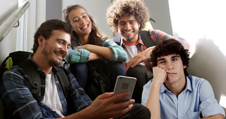 صورة شاب يستعمل هاتفه الجديد ليقول لأصدقائه أنه اشترى هاتفاً جديداً خلال مكالمة من هاتفه الجديد مؤكّداً لهم أنَّ هاتفه الجديد جديد