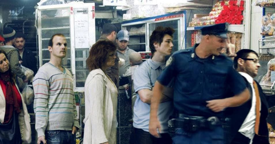 صورة ضابط يذكر المواطنين بهيبة الدولة عن طريق تجاوز الطابور في المخبز