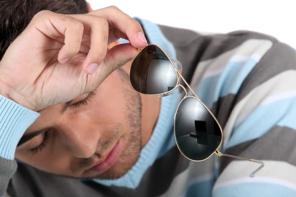 صورة شاب جامعي يخلع نظاراته الشمسية ليأخذ استراحة من تَفَحّص الفتيات