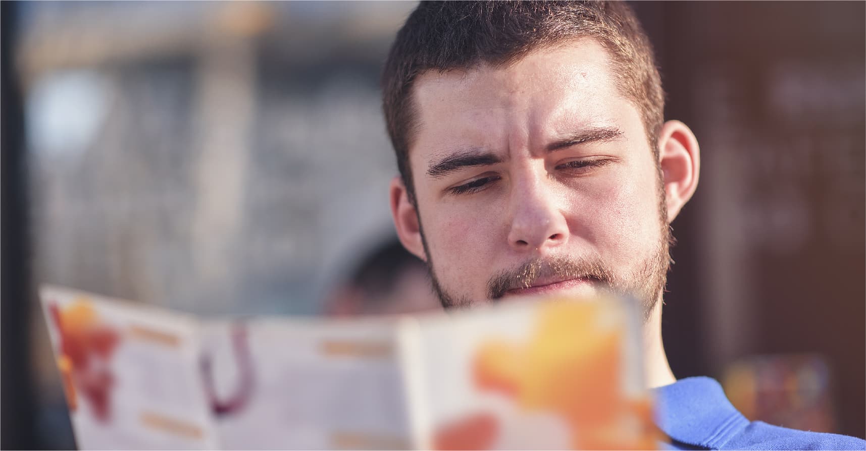 صورة شاب يرفع معدّل القراءة في العالم العربي ويقرأ لائحة الطعام في مطعم